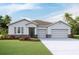 Charming single-story home features a two-car garage and manicured lawn at 3053 Canopy Oak Blvd, Wildwood, FL 34785