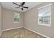 Comfortable bedroom with neutral paint, carpet, a ceiling fan, and natural light from two windows at 3918 Nw 46Th Ter, Ocala, FL 34482
