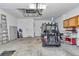 Spacious garage featuring an overhead door, lighting, side entrance, and golf cart at 3918 Nw 46Th Ter, Ocala, FL 34482