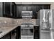Modern kitchen with stainless steel appliances, granite counters, and dark cabinetry at 3918 Nw 46Th Ter, Ocala, FL 34482