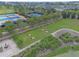 Aerial view featuring tennis courts, a horseshoe pit, and community recreation area near lush landscaping at 3918 Nw 46Th Ter, Ocala, FL 34482