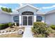 Close-up view of a white and blue home's front entrance, featuring a secure gated door and lush landscaping at 4085 Sw 110Th St, Ocala, FL 34476