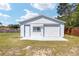 Detached one-car garage with white siding, blue trim, and concrete approach in a spacious yard at 4085 Sw 110Th St, Ocala, FL 34476