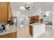 A kitchen with tile flooring and wood cabinetry, adjacent to the breakfast bar and living spaces at 4085 Sw 110Th St, Ocala, FL 34476