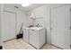 Functional laundry room with washer, dryer, tile floor, and convenient storage at 4085 Sw 110Th St, Ocala, FL 34476