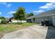 Well-maintained backyard featuring lush grass, mature trees, and an air conditioning unit on the side of the home at 4401 Sw 44Th Ln, Ocala, FL 34474