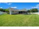 Large backyard featuring a screened-in porch, a pergola, and a pristine lawn at 4401 Sw 44Th Ln, Ocala, FL 34474