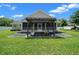 Screened-in porch with a pergola on a beautiful day with a well-maintained lawn at 4401 Sw 44Th Ln, Ocala, FL 34474