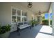 Inviting front porch with bench seating, decorative plants and lighting that accentuates the entrance at 4401 Sw 44Th Ln, Ocala, FL 34474