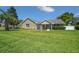 Charming single-story home featuring a stone facade, lush green lawn, and well-manicured landscaping at 4401 Sw 44Th Ln, Ocala, FL 34474