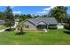 Beautiful home featuring stone accents, mature trees, and a well-manicured lawn at 4401 Sw 44Th Ln, Ocala, FL 34474