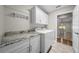 Laundry room featuring granite countertops, overhead cabinets, and a laundry sink at 4401 Sw 44Th Ln, Ocala, FL 34474