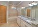 Bright bathroom featuring a tiled shower, a large soaking tub, and double sinks with a granite countertop at 4763 Se 25Th Loop, Ocala, FL 34480
