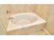 Bathroom features a large soaking tub with beige stone tile at 4763 Se 25Th Loop, Ocala, FL 34480