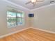 This bedroom has hardwood floors, a ceiling fan, a television, and a window view at 4763 Se 25Th Loop, Ocala, FL 34480