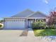 Charming single-Gathering home featuring a two-car garage, blue front door, and well-maintained landscaping at 4763 Se 25Th Loop, Ocala, FL 34480