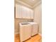 This laundry room contains overhead cabinets as well as a washer and dryer set at 4763 Se 25Th Loop, Ocala, FL 34480