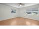 Bedroom features a ceiling fan, wood floors, and two windows with exterior view at 4810 County Road 114, Wildwood, FL 34785