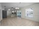 Bright living room with neutral tile flooring, open to the modern kitchen and screened patio at 4810 County Road 114, Wildwood, FL 34785