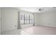 Bright living room with tile flooring, ceiling fan, and large window with neutral curtains at 4810 County Road 114, Wildwood, FL 34785