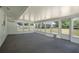 Enclosed sunroom addition with multiple windows, light blue walls, and access to the backyard at 4810 County Road 114, Wildwood, FL 34785