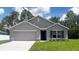 Charming single-story home with blue shutters, a two-car garage, and a well-manicured lawn at 553 Marion Oaks Mnr, Ocala, FL 34473