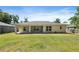 Rear exterior showcasing the home's windows, and a partially covered patio and backyard at 5591 Nw 57Th Pl, Ocala, FL 34482