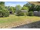 View of the home's backyard showcasing the lawn, trees, and partially fenced area at 5591 Nw 57Th Pl, Ocala, FL 34482