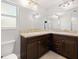 Bathroom features dual sinks, granite countertops, and large mirrors at 5591 Nw 57Th Pl, Ocala, FL 34482