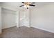 Bedroom with neutral carpeting, ceiling fan, and closet for organized storage solutions at 5591 Nw 57Th Pl, Ocala, FL 34482