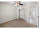 Bedroom featuring a closet, neutral carpet, ceiling fan and entry to en suite bathroom at 5591 Nw 57Th Pl, Ocala, FL 34482