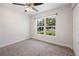 Cozy bedroom with carpeted floor and a large window providing ample natural light at 5591 Nw 57Th Pl, Ocala, FL 34482