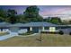 Inviting home with glowing windows, complemented by lush landscaping and a serene evening sky during twilight at 5591 Nw 57Th Pl, Ocala, FL 34482