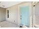 Up close view of the turquoise front door, showing the hardware, a Ring security camera, and the home's exterior at 5591 Nw 57Th Pl, Ocala, FL 34482