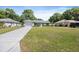Single-story home with a well-manicured lawn, a concrete driveway, and lovely landscaping around the entryway at 5591 Nw 57Th Pl, Ocala, FL 34482