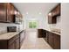 Open-concept kitchen showcasing granite counters, dark wood cabinets, and stainless steel appliances at 5591 Nw 57Th Pl, Ocala, FL 34482