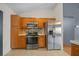 Kitchen featuring stainless steel appliances, wood cabinets, tile backsplash, and neutral countertops at 5900 Nw 61St Ct, Ocala, FL 34482