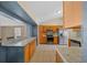 Kitchen featuring stainless steel appliances, wood cabinets, tile backsplash, and a pass-through to another room at 5900 Nw 61St Ct, Ocala, FL 34482