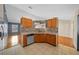 Bright kitchen featuring wood cabinets, tile backsplash, neutral countertops, and matching tile flooring at 5900 Nw 61St Ct, Ocala, FL 34482