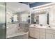 Bathroom with a double vanity, a large mirror, and a tiled tub with seashell decor at 6150 Nw 59Th Ave, Ocala, FL 34482
