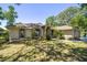 Well-maintained home showcasing a lush lawn, arched windows, and a side-entry garage at 6150 Nw 59Th Ave, Ocala, FL 34482