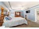 Spacious main bedroom featuring blue walls, tray ceilings, and wooden furniture at 6150 Nw 59Th Ave, Ocala, FL 34482