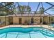 The pool has a glass ceiling over it and is surrounded by chairs and ladders at 6150 Nw 59Th Ave, Ocala, FL 34482