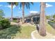 An inviting backyard with a stone-paved patio and lush landscaping, including mature palm trees at 7167 Sw 99Th Cir, Ocala, FL 34481