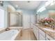 Bright primary bathroom with a soaking tub, glass shower, dual sinks, and granite countertops at 7167 Sw 99Th Cir, Ocala, FL 34481