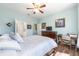 Comfortable bedroom boasts wood floors, a ceiling fan, and easy access to an ensuite bathroom at 7167 Sw 99Th Cir, Ocala, FL 34481