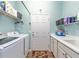 Functional laundry room features modern appliances, ample counter space, and shelving for efficient organization at 7167 Sw 99Th Cir, Ocala, FL 34481