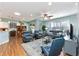 Open-concept living room with a ceiling fan, wood floors, and views of the dining area and patio at 7167 Sw 99Th Cir, Ocala, FL 34481