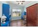 Bright office featuring hardwood floors, a window, and blue built-in shelving for ample storage and organization at 7167 Sw 99Th Cir, Ocala, FL 34481