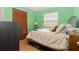 Well-lit bedroom features light green walls and a comfortable bed at 731 Cloverleaf Blvd, Deltona, FL 32725